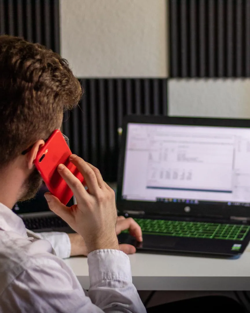 Student talking on the phone while using the computer.