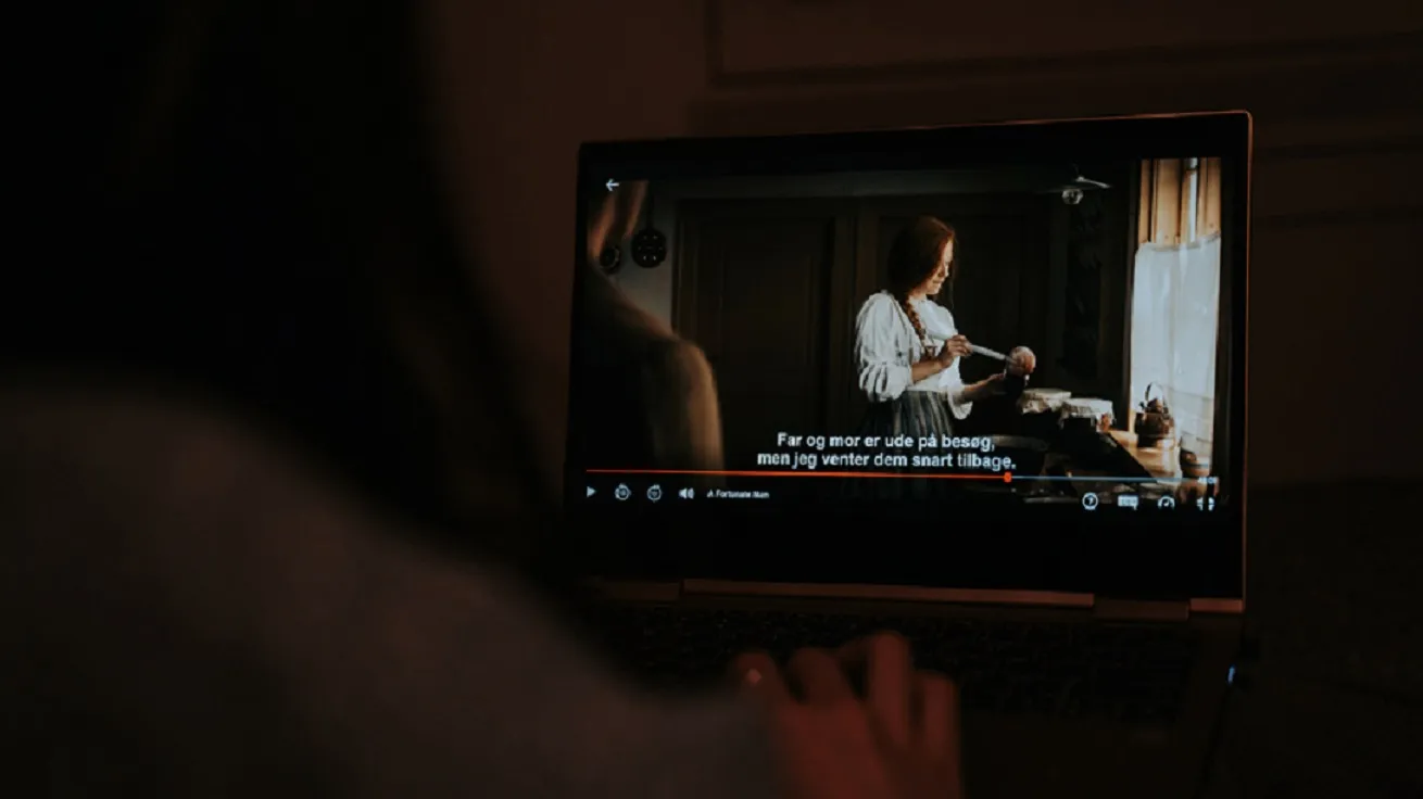 Woman watching Netflix show with Danish subtitles