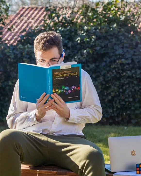 Student reading textbook about econometrics.