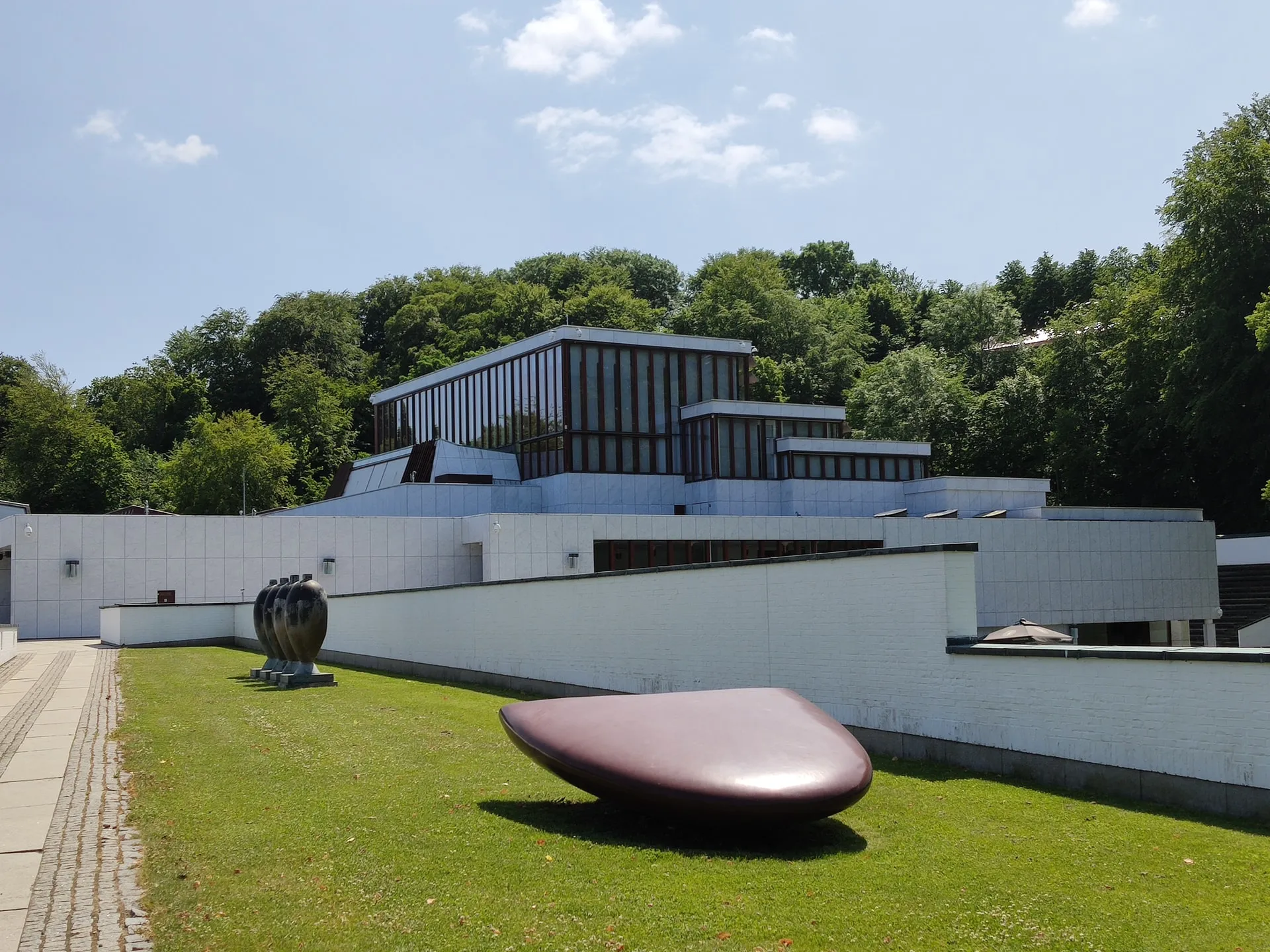 White building with modern art pieces in front